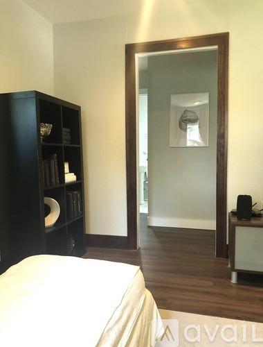 A bedroom with a bed, a bookshelf, and a mirror.