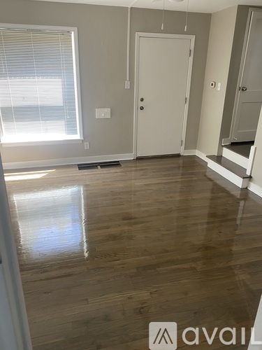 A room with wooden flooring and a white door.
