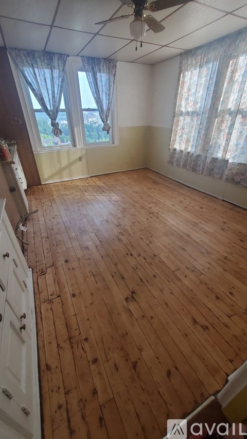 A room with wooden floors and a ceiling fan.