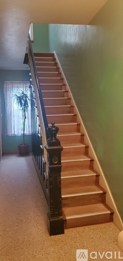 A staircase with a wooden handrail and beige steps.