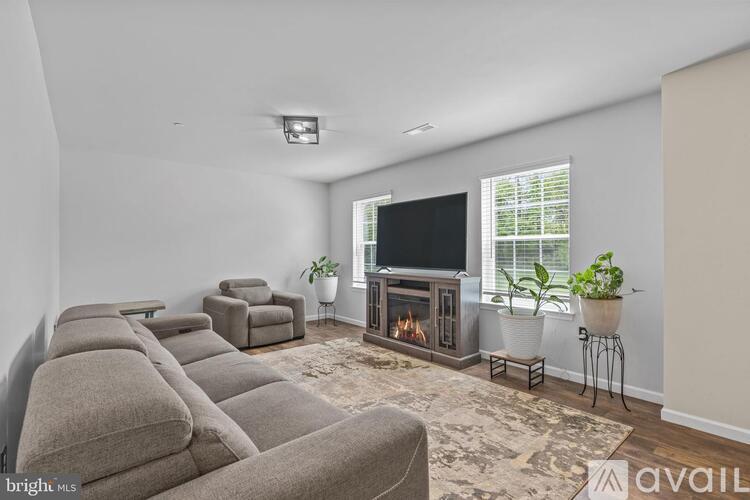 A living room with a grey couch and a fireplace.
