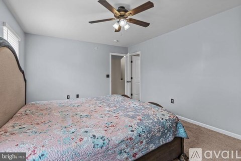 A bedroom with a bed and a ceiling fan.
