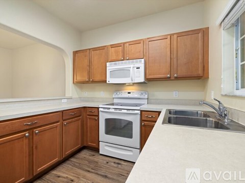 A kitchen with wooden cabinets and a white oven.