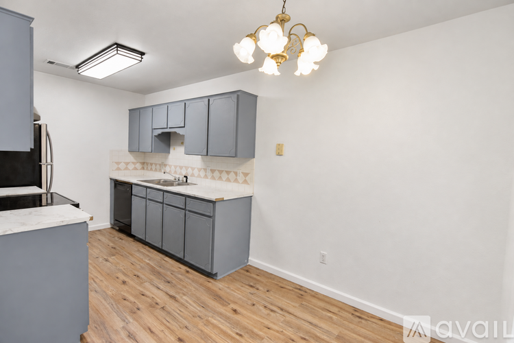 A kitchen with wooden floors and a white counter top.