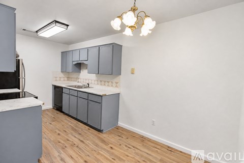 A kitchen with wooden floors and a white counter top.