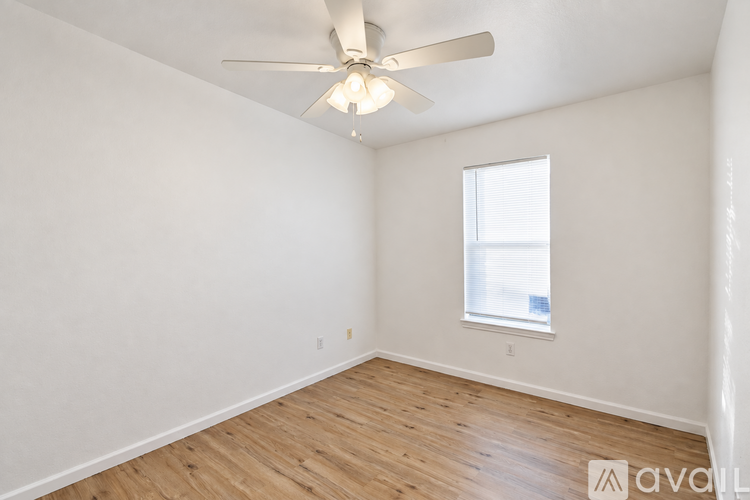 A room with a ceiling fan and a window.