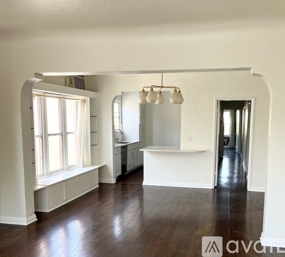 A spacious room with wooden floors and white walls.