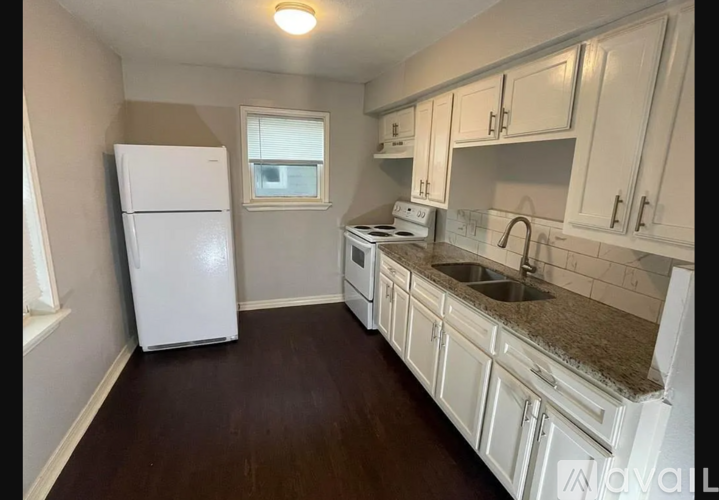A kitchen with white cabinets and a white fridge.