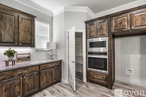 A kitchen with wooden cabinets and a stainless steel oven.