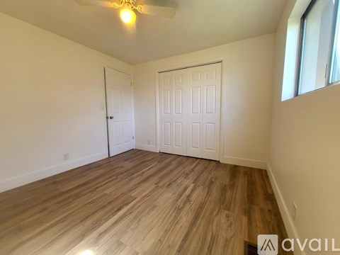 A room with wooden flooring and two doors.