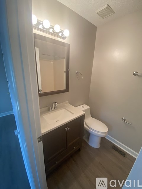 A bathroom with a sink, toilet, and mirror.