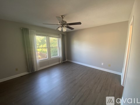 A room with a ceiling fan and sliding glass doors.