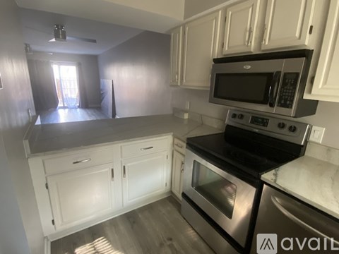 A kitchen with white cabinets and a black stove top oven.