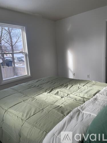 A bedroom with a bed and a window.