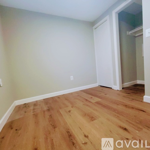 A room with wooden flooring and a white door.