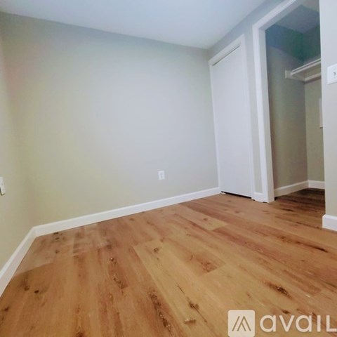 A room with wooden flooring and a white door.