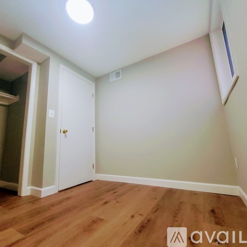 A room with wooden flooring and a white door.