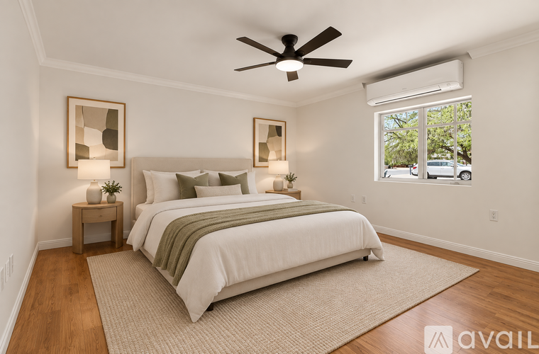 A bedroom with a large bed and a ceiling fan.
