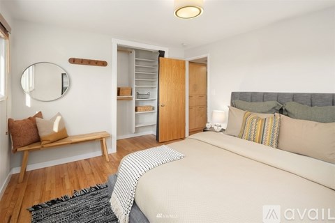 A bedroom with a bed, a bench, and a mirror on the wall.