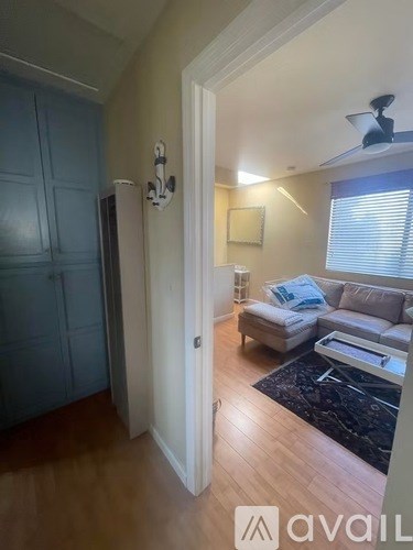 A living room with a couch and a fan.
