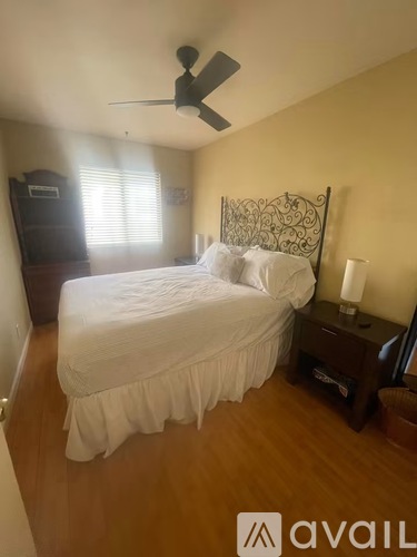 A bedroom with a bed, nightstand, and a ceiling fan.