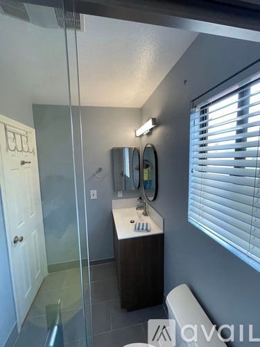 A bathroom with a sink, mirror, and a glass shower door.