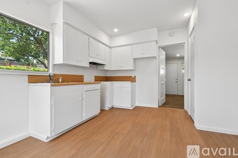 A kitchen with white cabinets and a wooden countertop.
