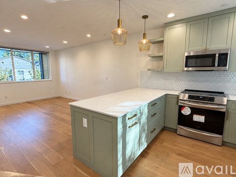 A kitchen with a stove top oven and a microwave above the island.