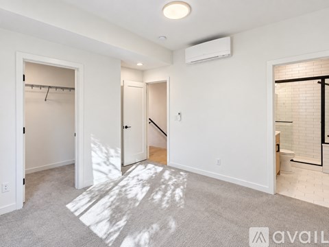 A spacious room with a carpeted floor and a white ceiling with a light fixture.