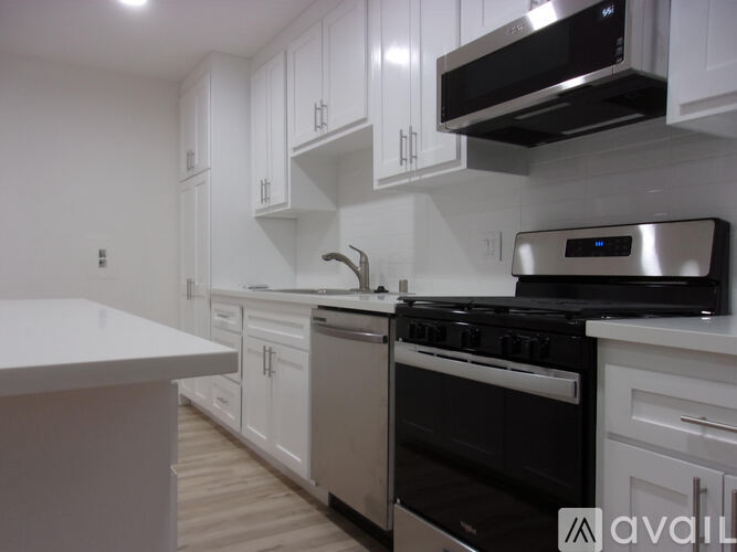 A modern kitchen with white cabinets and stainless steel appliances.