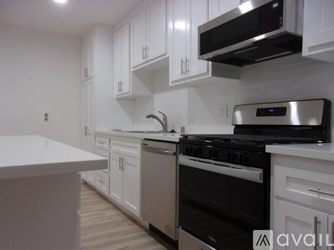A modern kitchen with white cabinets and stainless steel appliances.