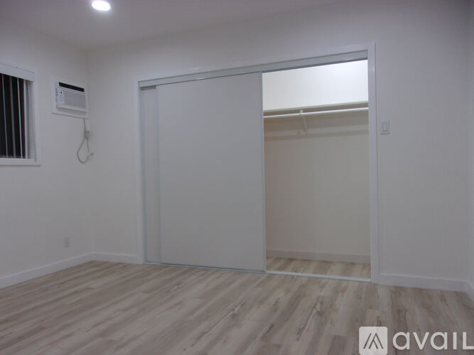 A room with a sliding door and a window with blinds.