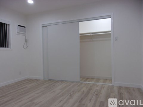 A room with a sliding door and a window with blinds.
