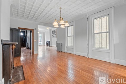 A spacious room with wooden floors and a white ceiling.