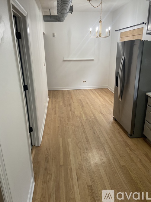 A kitchen with a refrigerator and a chandelier.