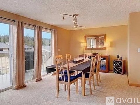 A dining room with a table and chairs.