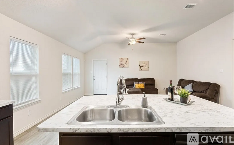 A kitchen with a marble countertop and a sink.