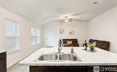 A kitchen with a marble countertop and a sink.