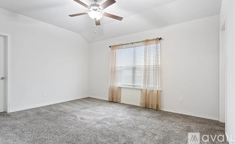 A room with a ceiling fan and carpeted floor.