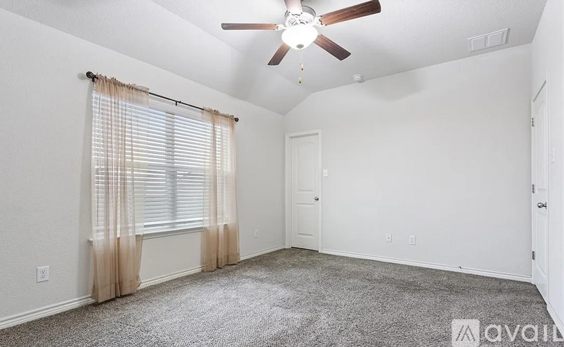A room with a ceiling fan and carpeted floor.