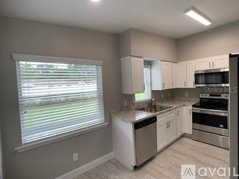 A kitchen with white appliances and cabinets is available for rent.