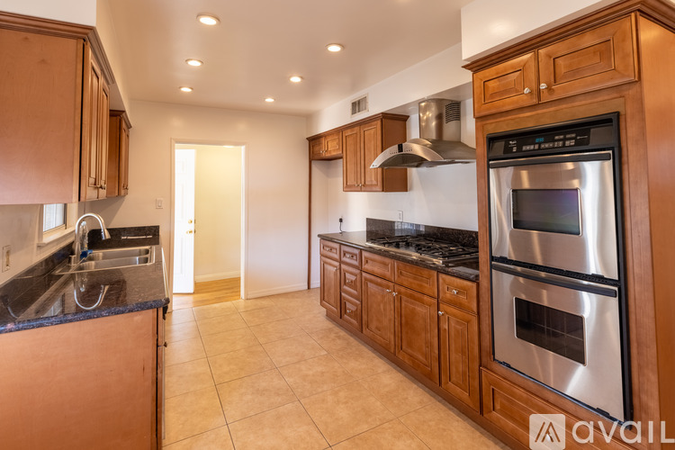 A kitchen with wooden cabinets and a black countertop.