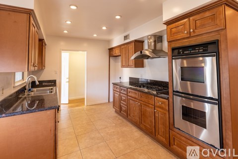 A kitchen with wooden cabinets and a black countertop.