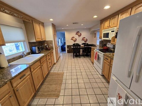 A kitchen with wooden cabinets and a white refrigerator.