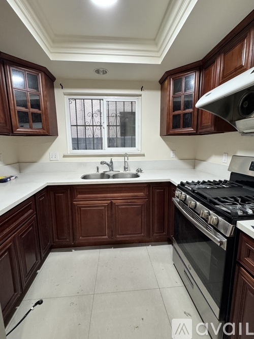 A kitchen with dark wood cabinets and a white countertop.