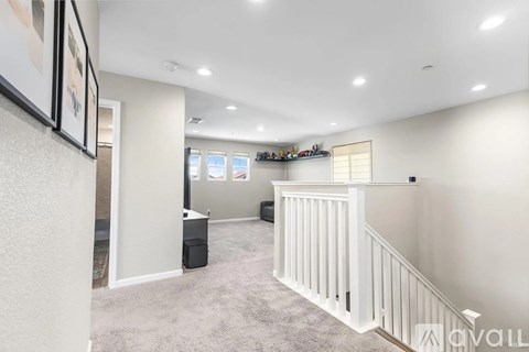 A spacious room with a staircase and a window.