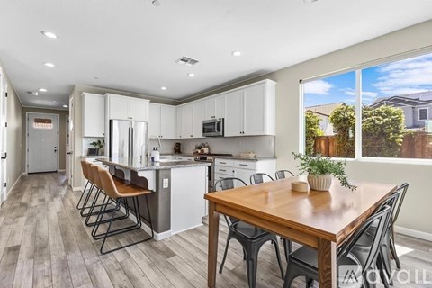 A kitchen with a table and chairs in front of a window.