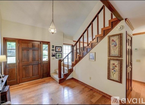 A living room with a staircase and pictures on the wall.