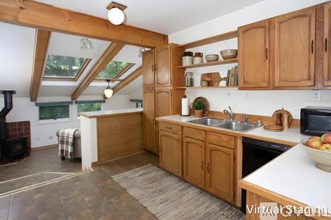 A kitchen with wooden cabinets and a skylight.