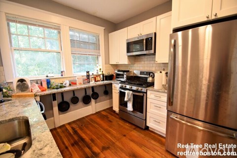 A kitchen with a stove top oven and a refrigerator.